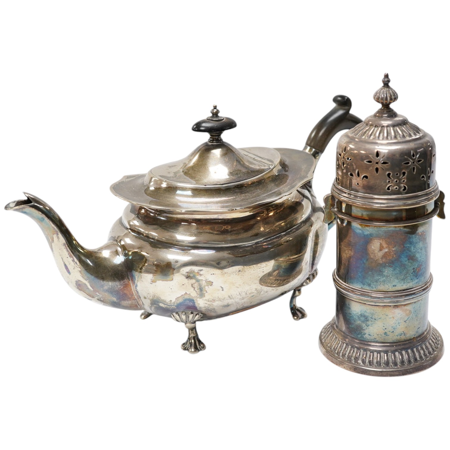 An Edwardian bachelor's silver teapot, Henry Wigful?, Sheffield, 1903, together with a George V silver lighthouse sugar caster by Atkin Brothers, 15.4cm, gross weight 19.5oz. Condition - poor to fair